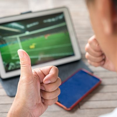 Man with thumbs up while watching football sports game on digital tablet. Live stream or sports online concept.